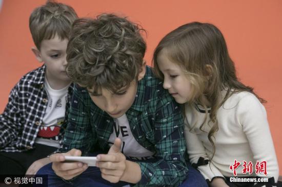 资料图：正在玩手机的儿童。图片来源：视觉中国